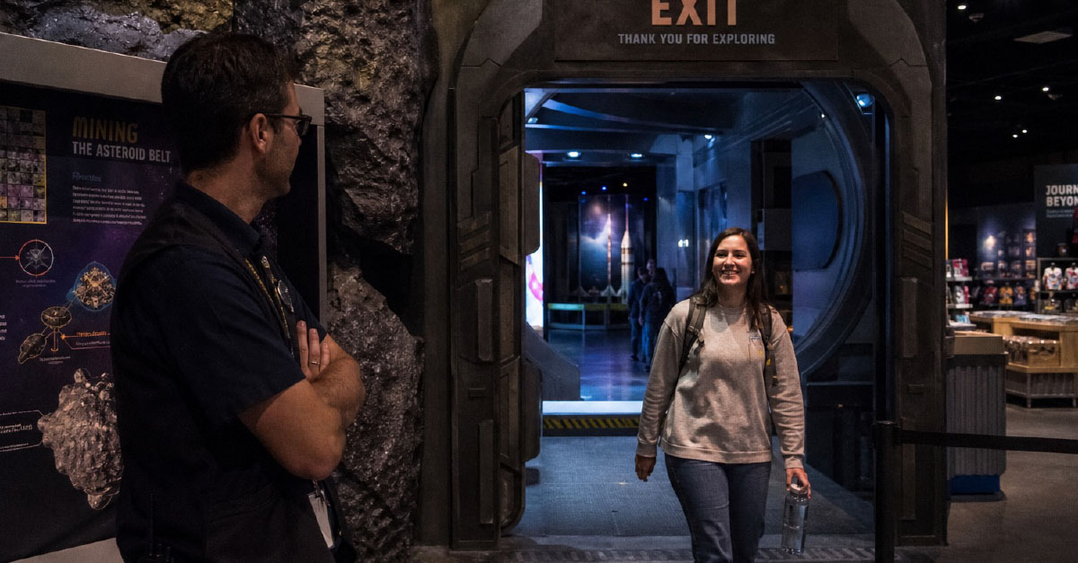 Visitor leaving an experience in museum smiling.